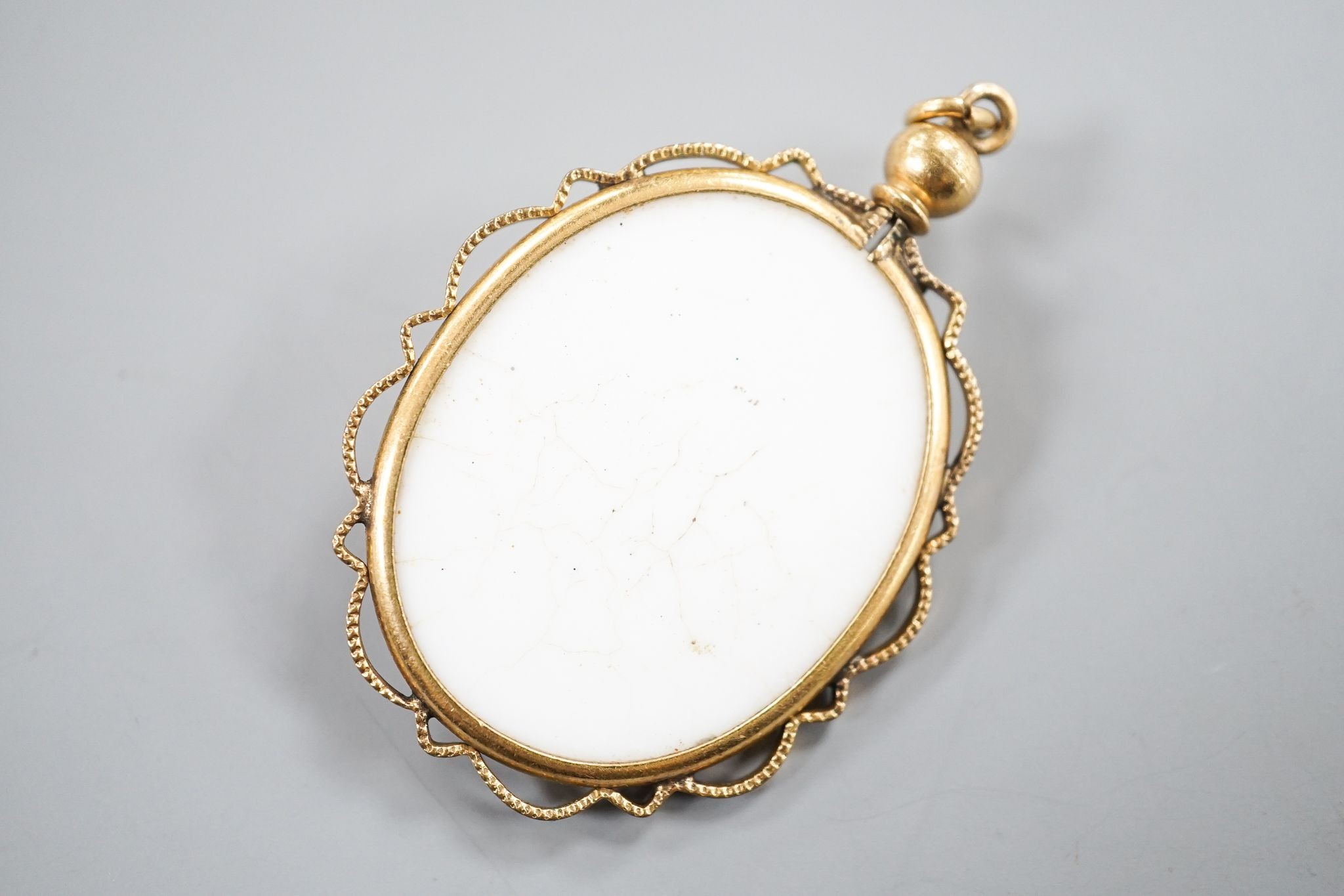 A gilt metal mounted oval ceramic? cameo pendant, 35mm.